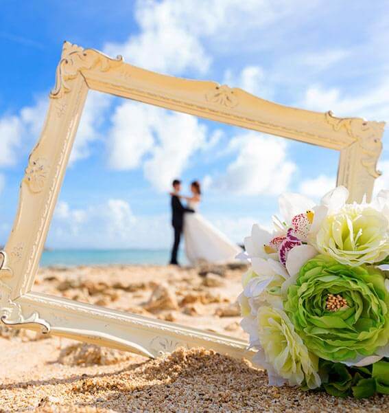 Wedding couple framed on beach with flowers.